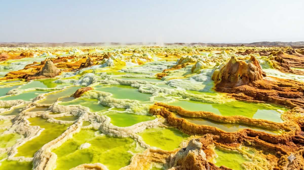 Paisaje volcánico de Dallol con piscinas de azufre amarillo y verde en Etiopía.